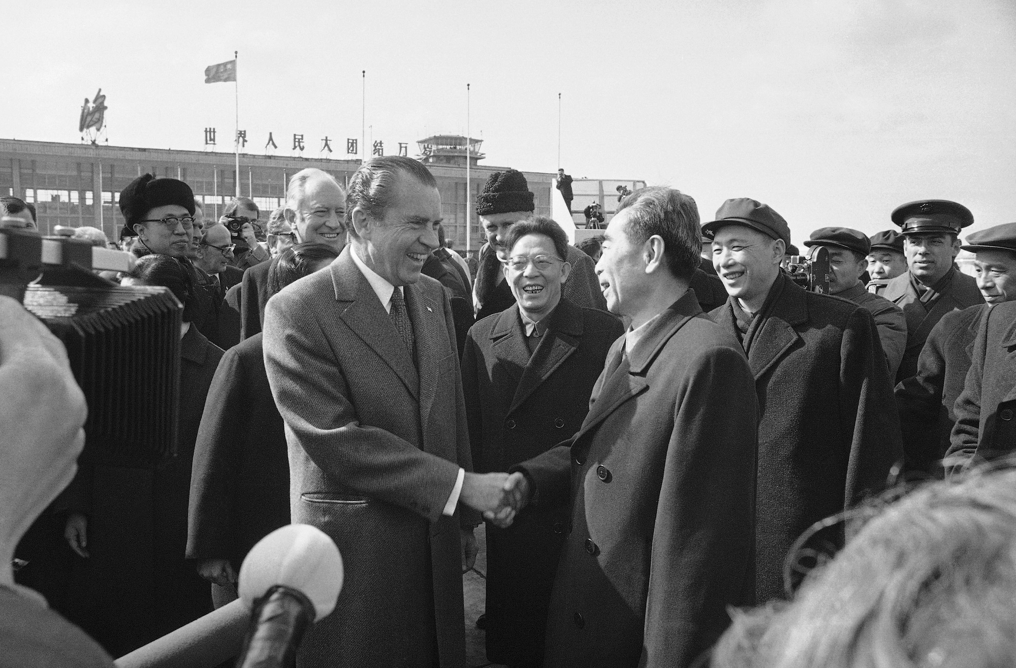 1972 black-and-white photograph of President Nixon shaking hands with Chinese Premier Zhou Enlai on an airport tarmac.